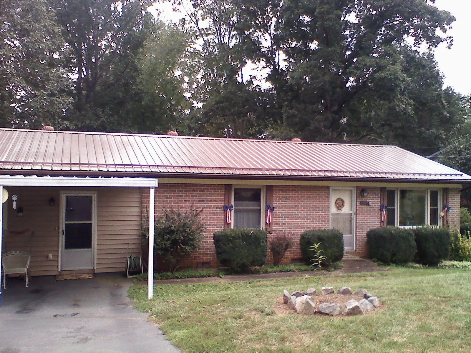 Bronze metal roof and carport on a brick ranch home — Roof Repair work by our crew in Christine